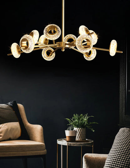Modern LED chandelier with gold finish. This chandelier features a series of metal rings with crystal shape glass, each embedded with LED lights that cast a radiant sparkle through the glass.